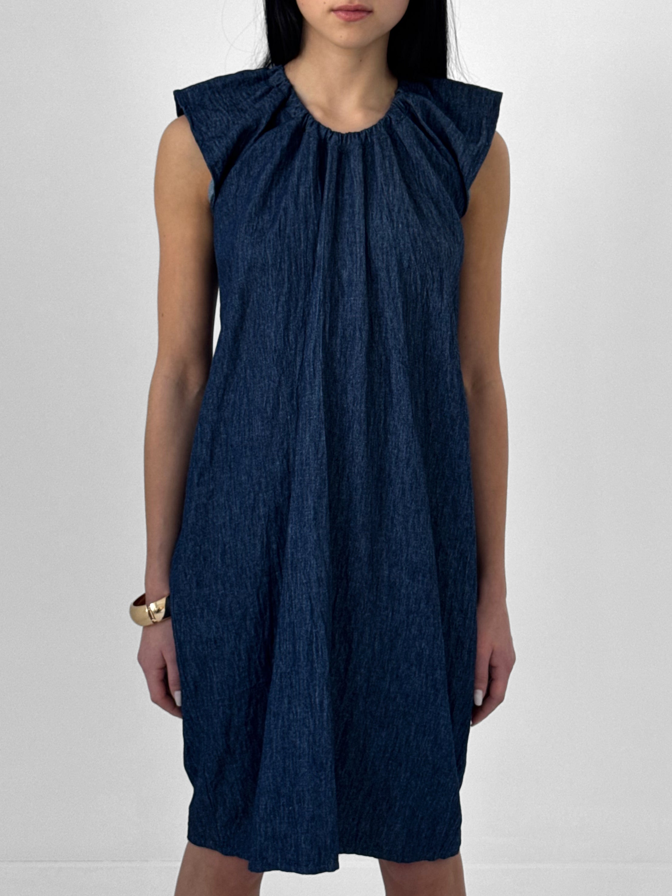 Woman wearing a blue denim dress on a white background