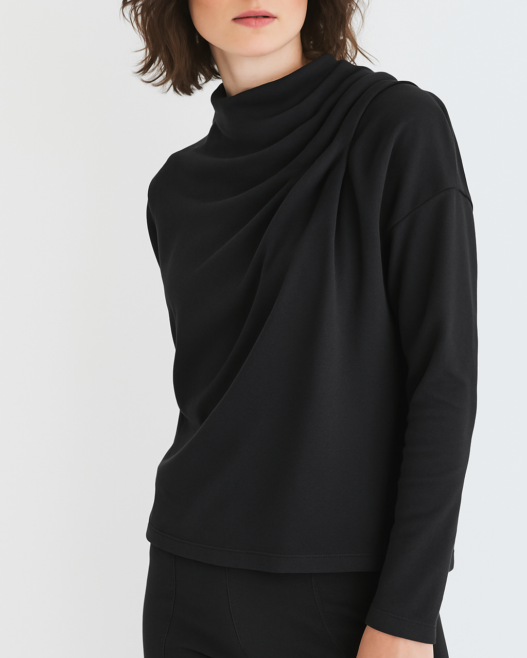 Woman wearing a black long-sleeve top on a white background