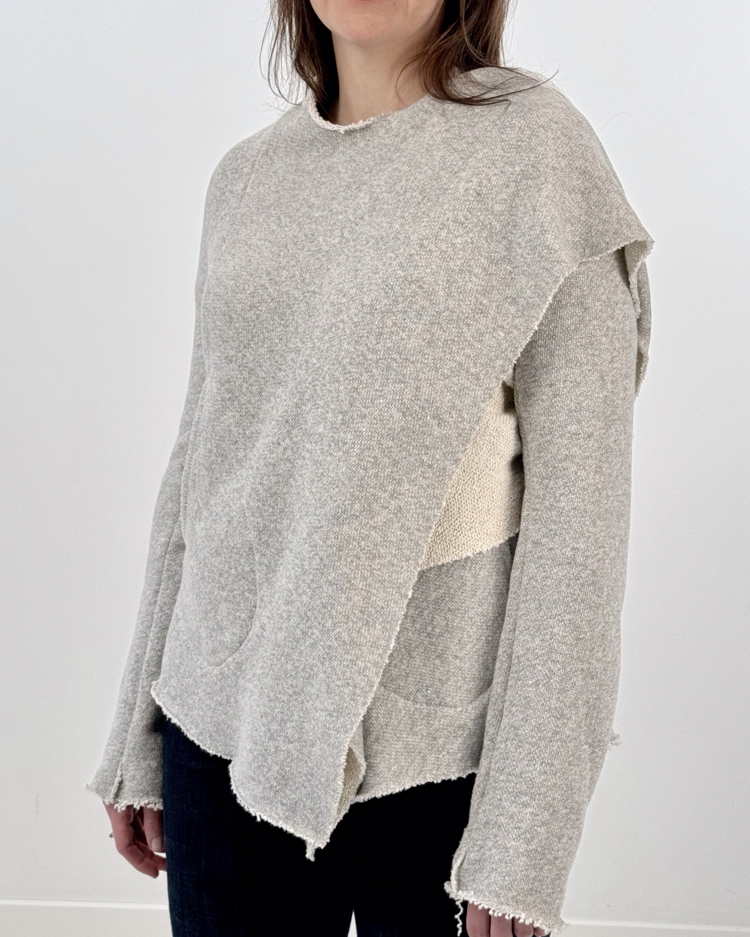 Woman wearing a gray and white wrap jacket against a white background