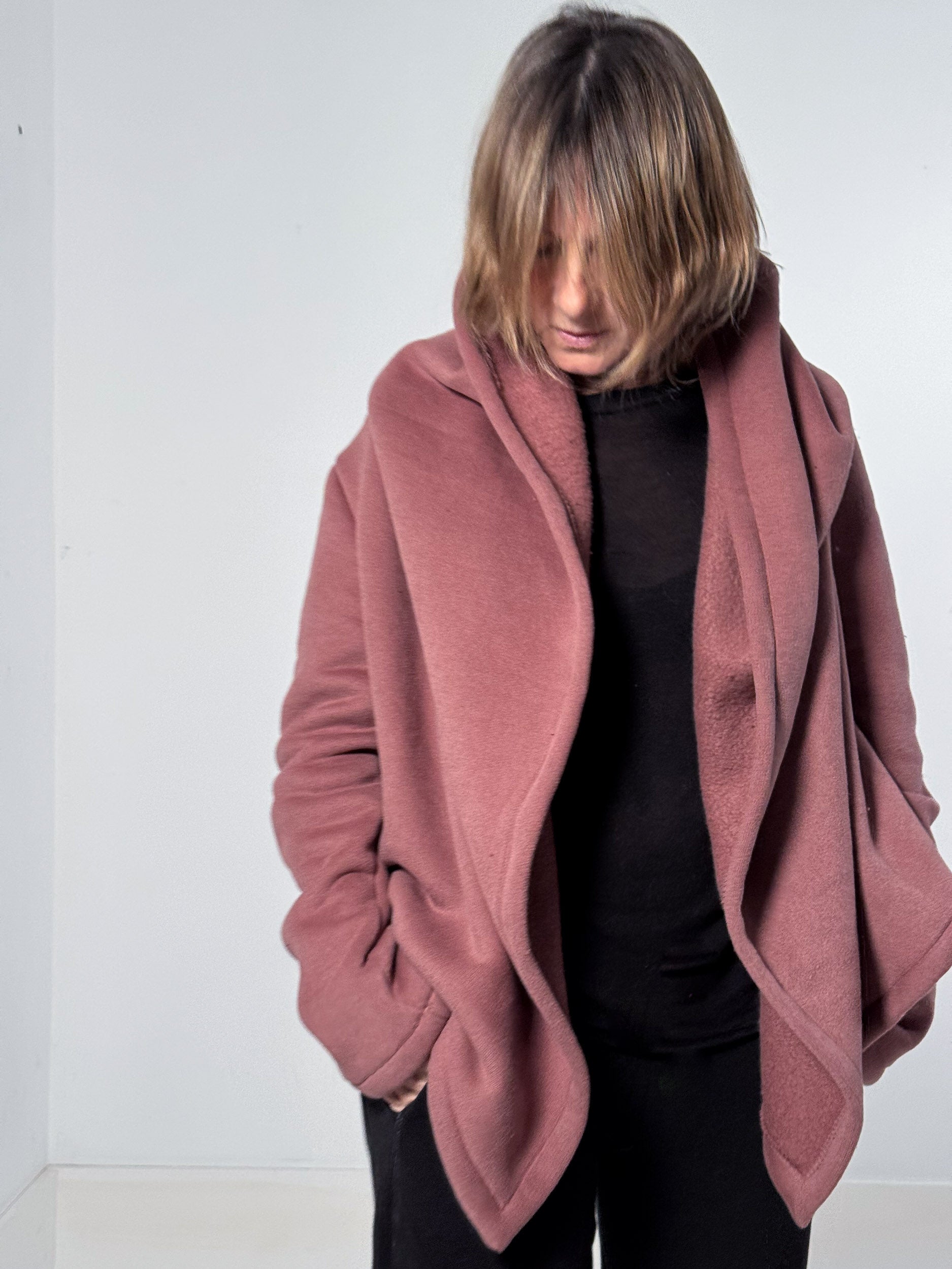 Person wearing a pink coat against a white background