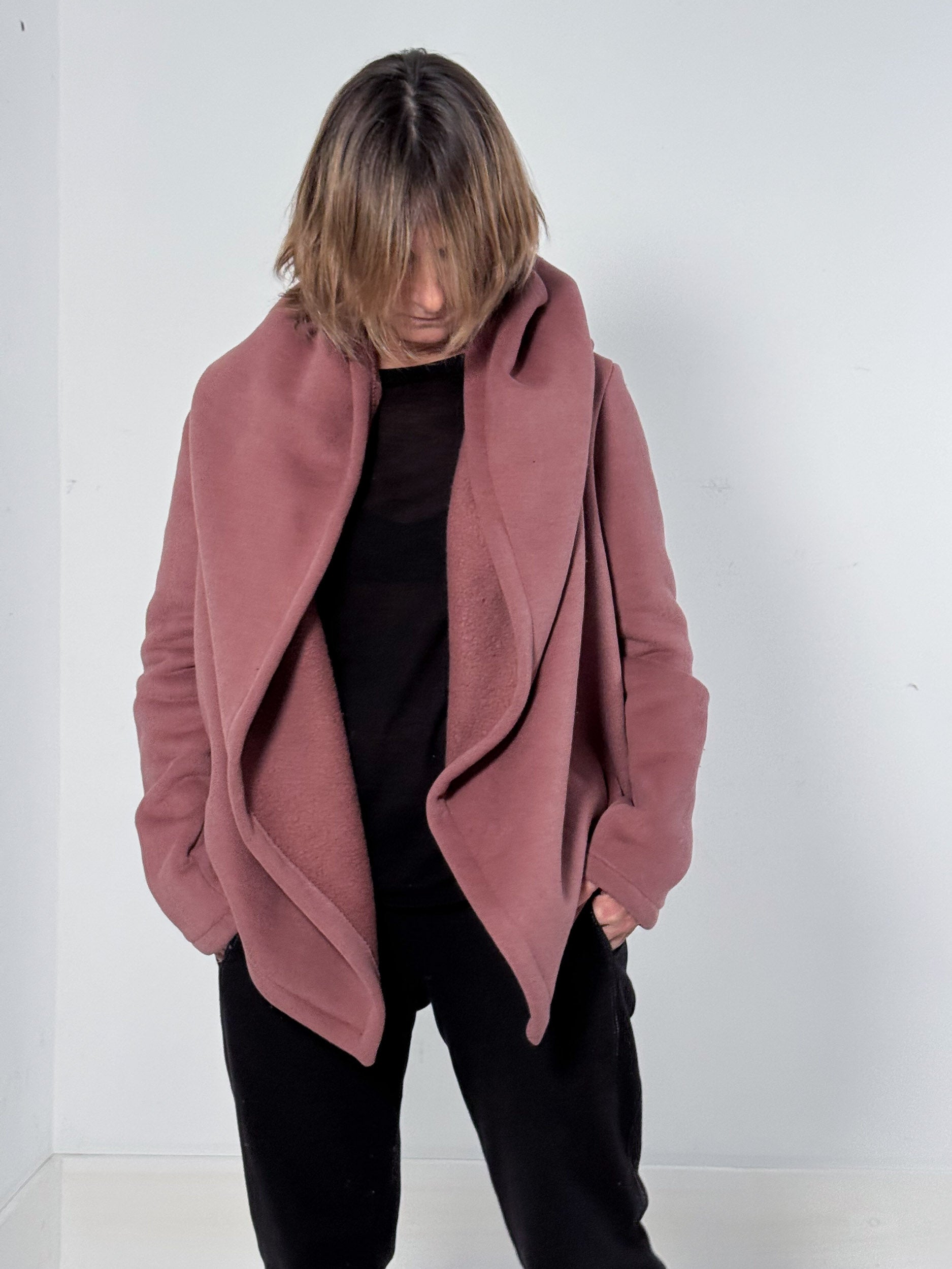 Person wearing a pink coat against a white background