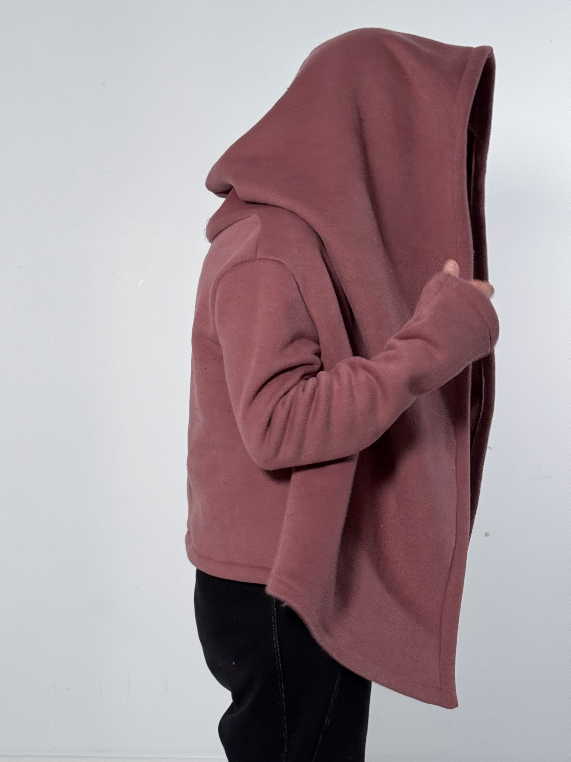 Person wearing a mauve hoodie on a white background