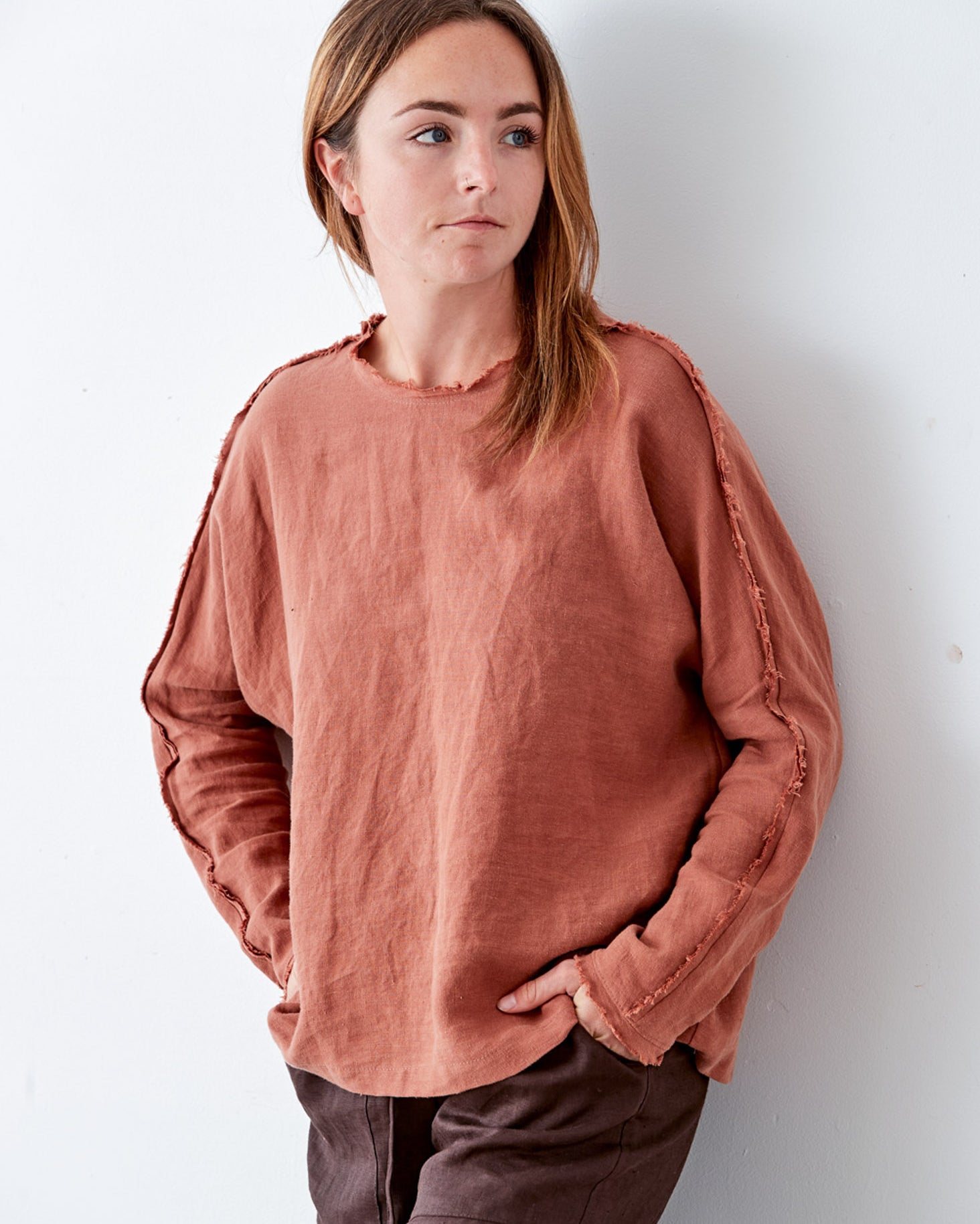 Person wearing a rust-colored shirt against a white background