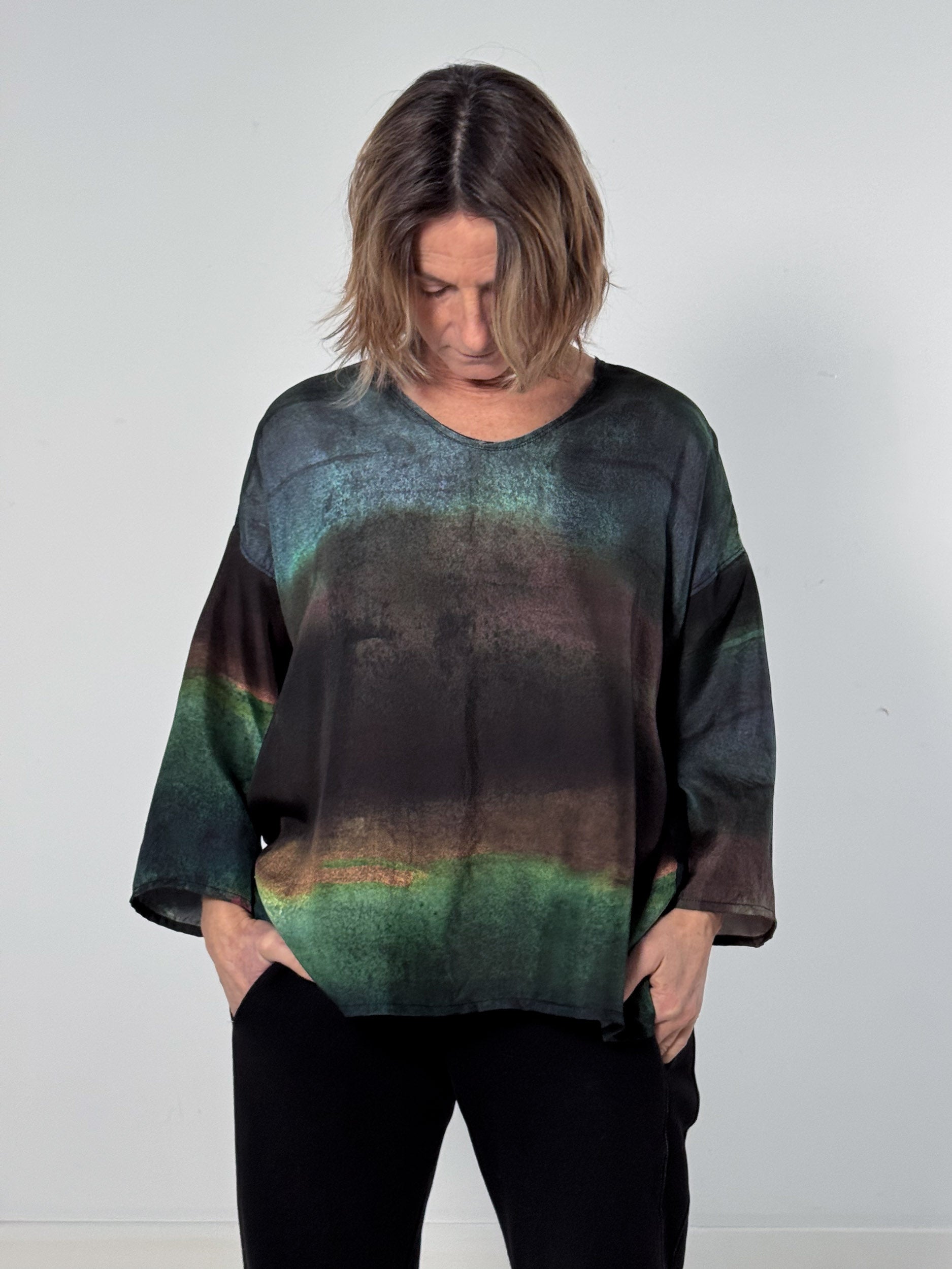 Person wearing a dark, textured sweater with a gradient effect against a plain background