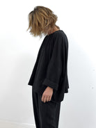 Person wearing a black outfit against a white background