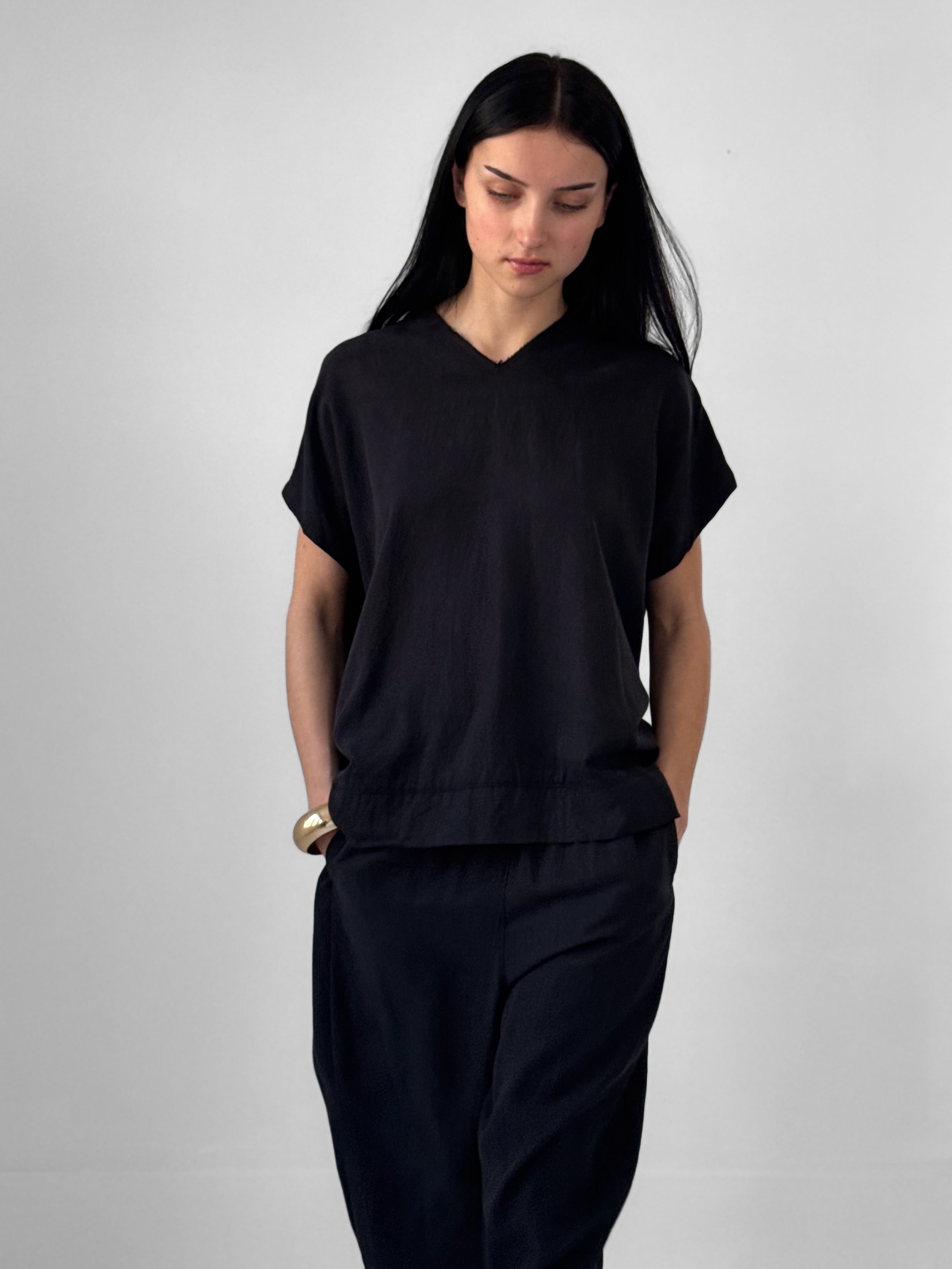 Lark washed tencel top with raw edge high V neckline and relaxed fluid silhouette, black minimalist blouse in modern understated style