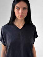 Lark washed tencel top with raw edge high V neckline and relaxed fluid silhouette, black minimalist blouse in modern understated style