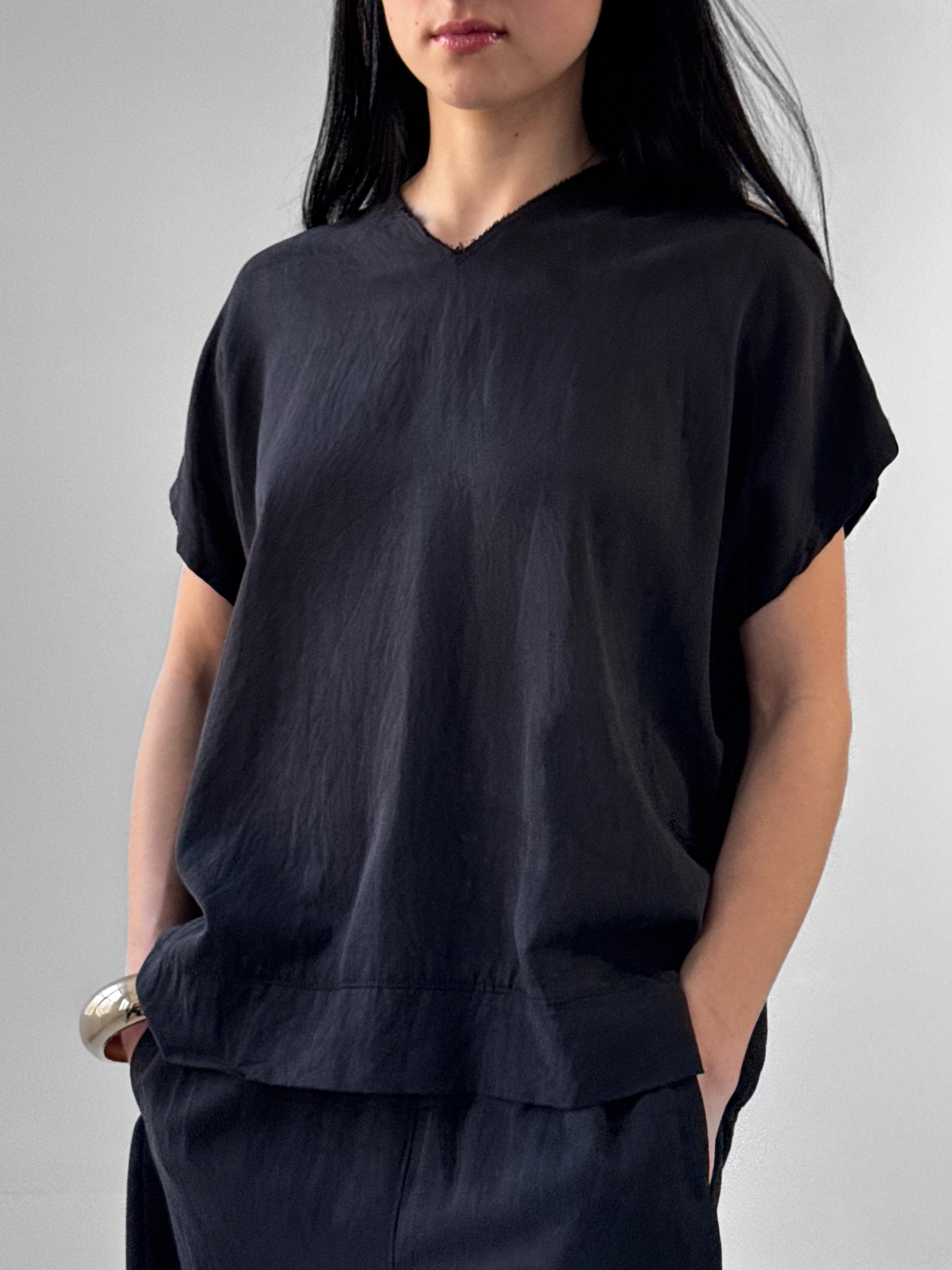 Lark washed tencel top with raw edge high V neckline and relaxed fluid silhouette, black minimalist blouse in modern understated style