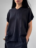 Lark washed tencel top with raw edge high V neckline and relaxed fluid silhouette, black minimalist blouse in modern understated style