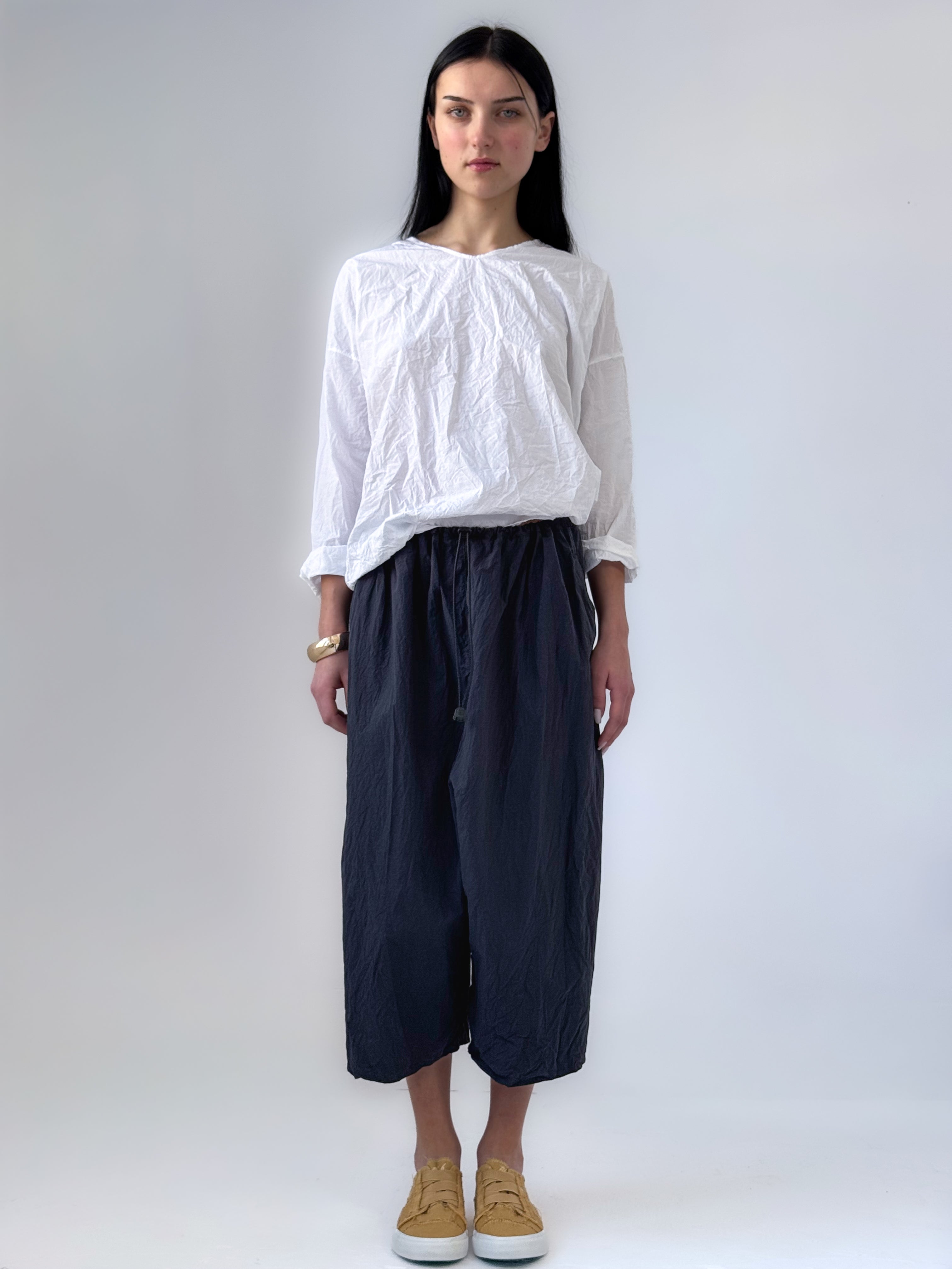 Noor drop crotch pants in crumpled black cotton with drawstring waist and relaxed cropped silhouette