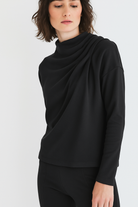 Woman wearing a black long-sleeve top on a white background
