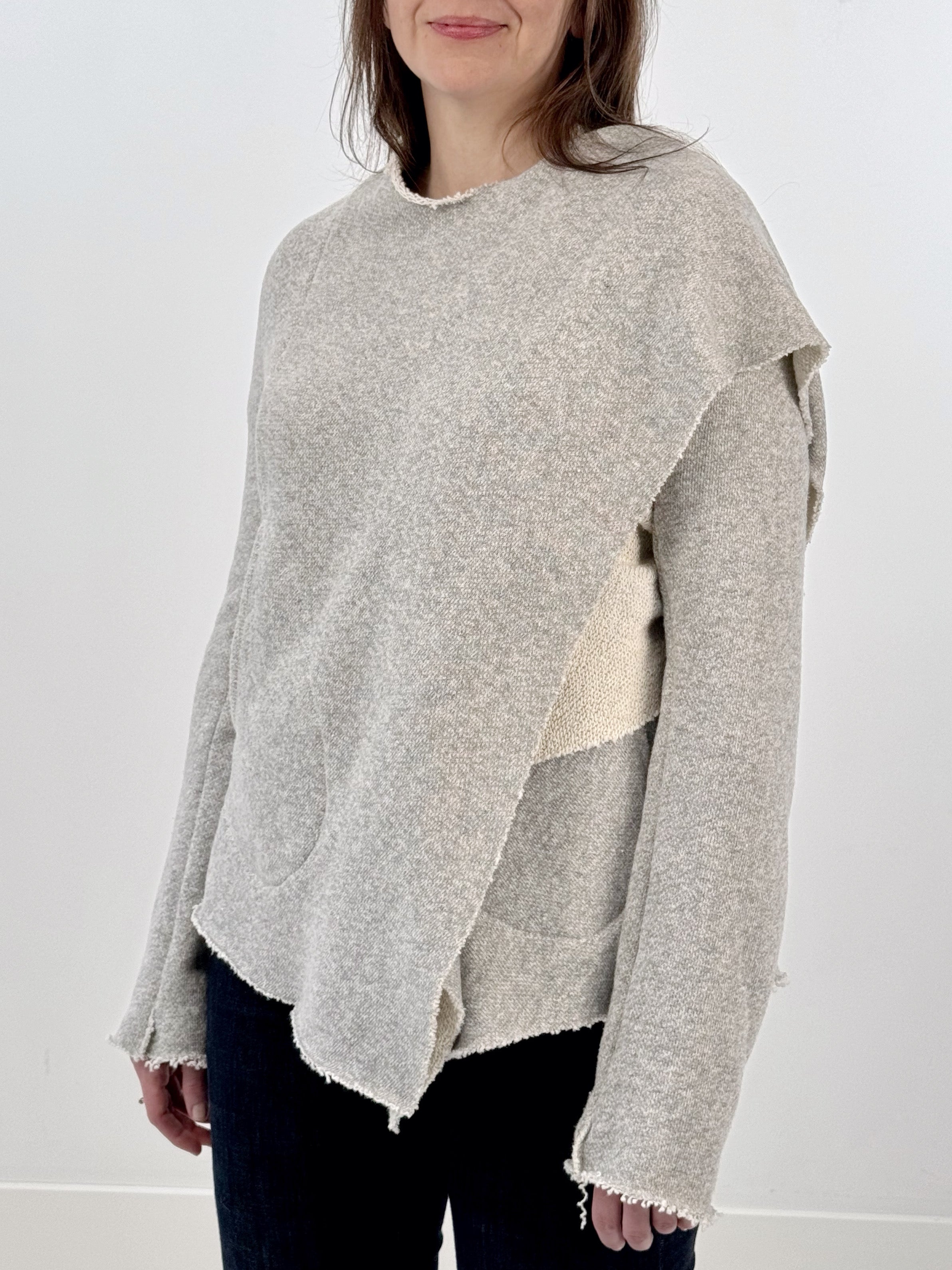 Woman wearing a gray and white wrap jacket against a white background