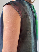 Close-up of a sleeveless garment with a gradient design on a plain background